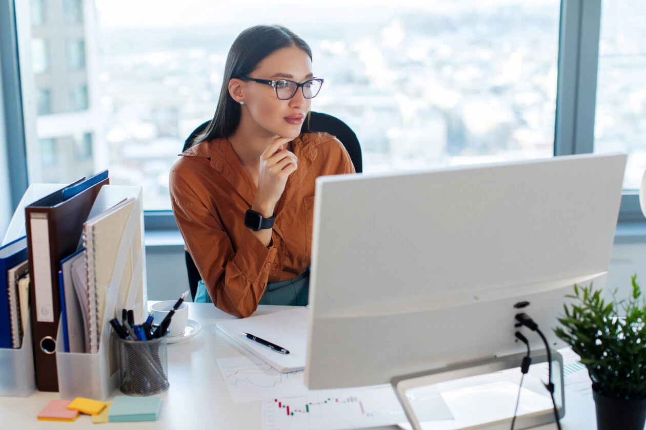 Women in business concentrated sitting in front of computer monitor