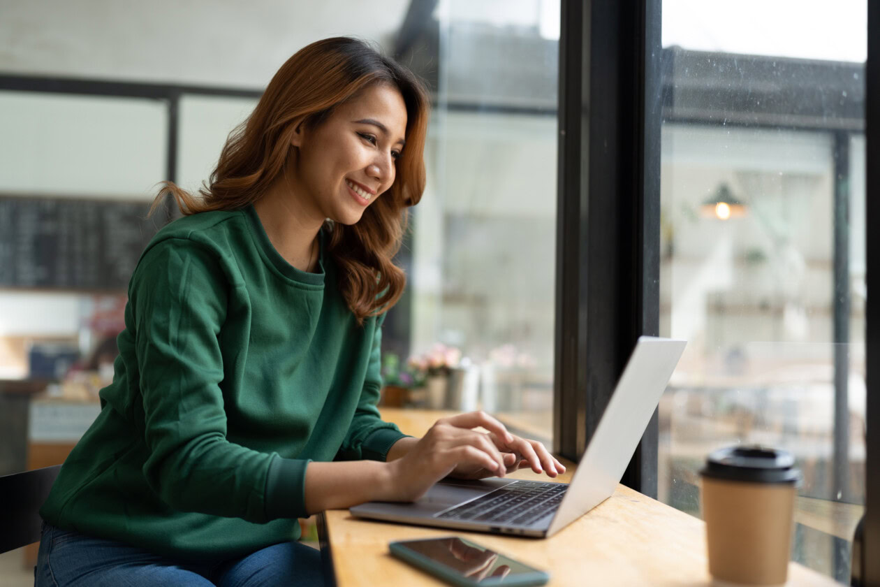 Asian woman working with laptop in coffee shop